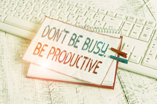 Word writing text Don T Be Busy Be Productive. Business concept for Work efficiently Organize your schedule time notebook paper reminder clothespin pinned sheet white keyboard light wooden.