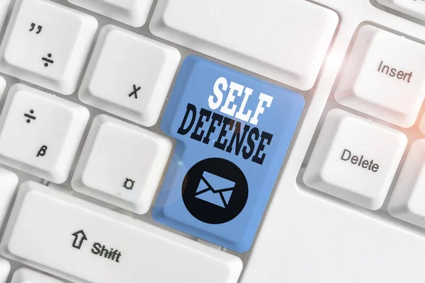 Conceptual hand writing showing Self Defense. Business photo showcasing the act of defending one s is demonstrating when physically attacked White pc keyboard with note paper above the white backgroun