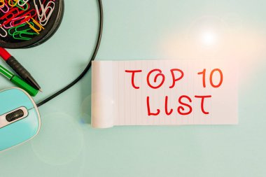 El yazısı metni Top 10 Listesi. Kavram, belirli bir liste içerisindeki en önemli ve en başarılı on öge anlamına gelir Not defteri ve yazma ekipmanı Pastel arkaplan üzerinde bilgisayar faresi ile.