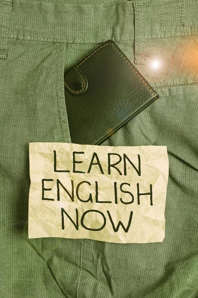 Word writing text Learn English Now. Business concept for gain or acquire knowledge and skill of english language Small little wallet inside man trousers front pocket near notation paper.