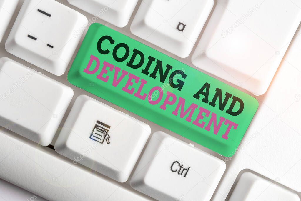 Handwriting text writing Coding And Development. Concept meaning Programming Building simple assembly Programs White pc keyboard with empty note paper above white background key copy space.