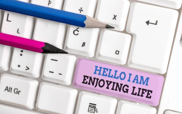 Testo calligrafico Hello I Am Enjoying Life. Concetto che significa Felice stile di vita rilassato Godetevi cose semplici Tastiera bianca pc con carta nota vuota sopra lo spazio di copia chiave sfondo bianco . — Foto Stock