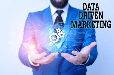 Writing note showing Data Driven Marketing. Business photo showcasing Strategy built on Insights Analysis from interactions Male human wear formal suit presenting using smart device.
