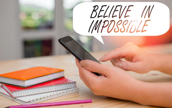 Conceptual hand writing showing Believe In Impossible. Business photo text You can do it everything is possible Work hard woman using smartphone and technological devices inside the home.