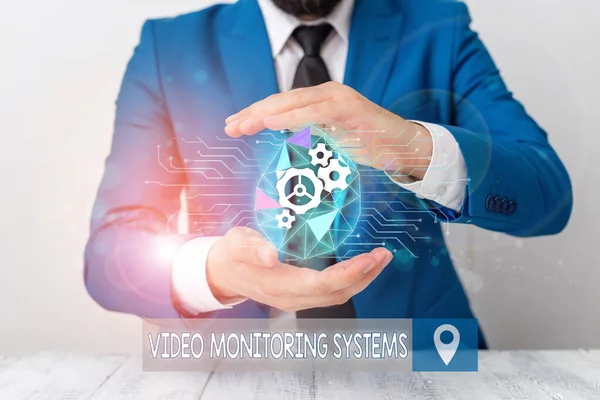 Conceptual hand writing showing Video Monitoring Systems. Business photo text Surveillance Transmit capture Image to Digital Link Male human wear formal suit presenting using smart device. — Stock Photo, Image