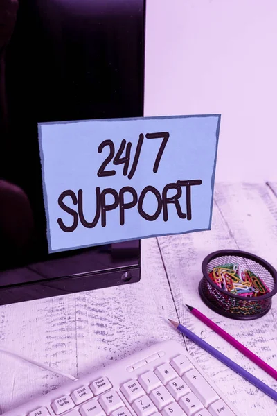 Conceptual hand writing showing 24 Or 7 Support. Business photo text Giving assistance to service whole day and night No downtime Note paper taped to black screen near keyboard stationary. — 스톡 사진