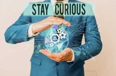 Conceptual hand writing showing Stay Curious. Business photo showcasing attention through being inexplicable or highly unusual Male human wear formal suit presenting using smart device.