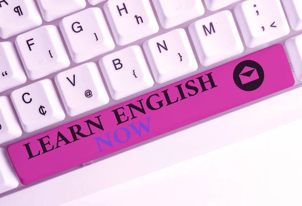 Text sign showing Learn English Now. Conceptual photo gain or acquire knowledge and skill of english language White pc keyboard with empty note paper above white background key copy space.