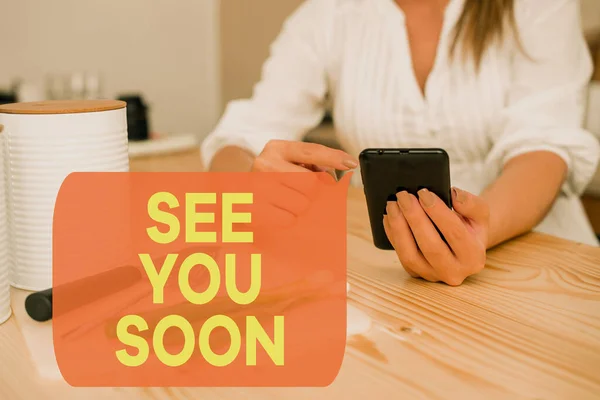 Writing note showing See You Soon. Business photo showcasing used for saying goodbye to someone and going to meet again soon woman using smartphone and technological devices inside the home. — Stockfoto