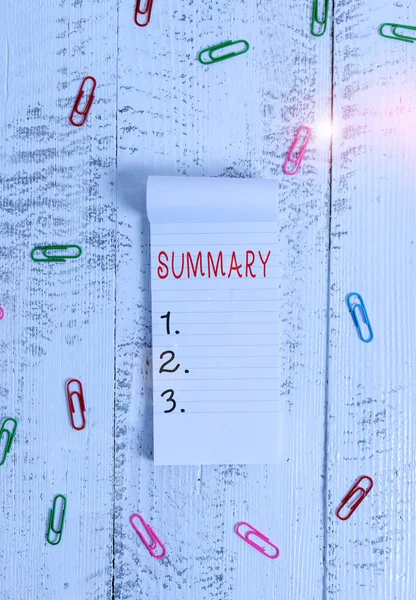 Text sign showing Summary. Conceptual photo a brief statement or account of the main points of something Stripped ruled notepad clips lying wooden old retro vintage background.