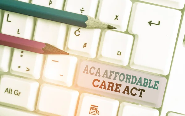 Text psaný rukou Aca Affordable Care Act. Koncept znamená poskytování levné léčby pro pacienta na několika místech Bílá PC klávesnice s prázdným poznámkovým papírem nad bílým pozadí klíč kopírovat prostor. — Stock fotografie