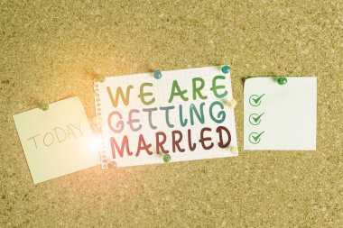 Handwriting text We Are Getting Married. Concept meaning Engagement Wedding preparation Loving couple Corkboard color size paper pin thumbtack tack sheet billboard notice board.