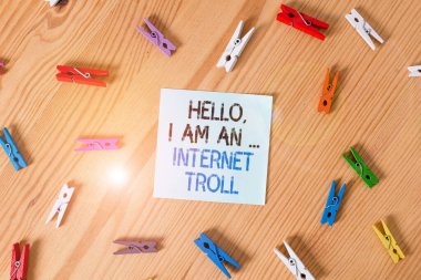 Writing note showing Hello I Am An Internet Troll. Business photo showcasing Social media troubles discussions arguments Colored clothespin papers empty reminder wooden floor background office.