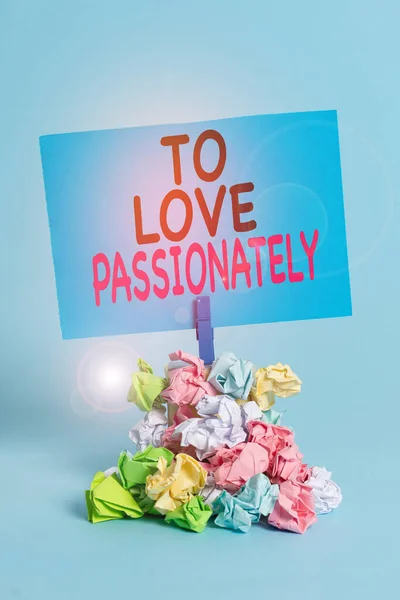 Szöveg jel mutatja To Love szenvedélyesen. Fogalmi fotó Erős érzés valaki vagy valami más Szeretetemlékeztető halom színes összegyűrt papír ruhacsap emlékeztető kék háttér. — Stock Fotó
