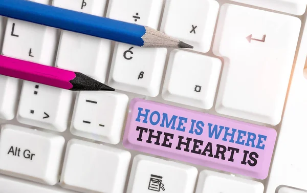 Handschrift Text nach Hause ist, wo das Herz ist. Konzept bedeutet, dass Ihr Haus ist, wo Sie sich wohl und glücklich fühlen weiße PC-Tastatur mit leerem Notizpapier über weißem Hintergrund Schlüssel Kopierraum. — Stockfoto