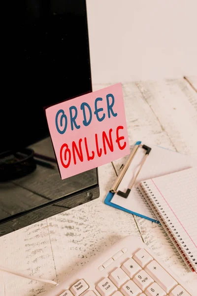 Writing note showing Order Online. Business photo showcasing activity of buying products or services over the Internet Note paper taped to black computer screen near keyboard and stationary. — 스톡 사진