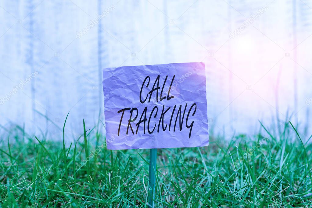 Conceptual hand writing showing Call Tracking. Business photo text Organic search engine Digital advertising Conversion indicator Plain paper attached to stick and placed in the grassy land.