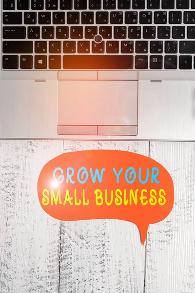Woord schrijven tekst Grow Your Small Business. Bedrijfsconcept voor bedrijf genereert positieve cashflow Earn Close view open laptop blank spraakbel naar beneden liggende vintage tafel. — Stockfoto