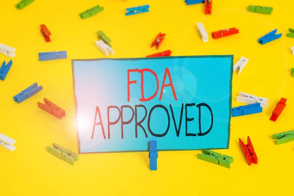Az üzenet szerint FDA jóváhagyva. Fogalmi fotó Fda egyetértett abban, hogy a termék vagy képlet biztonságos és hatékony Színes ruhacsap papírok üres emlékeztető sárga padló háttér iroda. — Stock Fotó