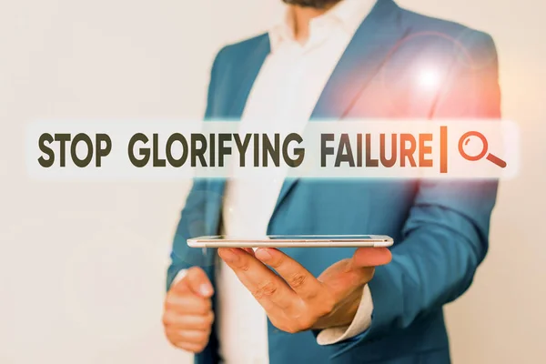 Znak tekstowy pokazujący Stop Glorifying Failure. Zdjęcie koncepcyjne nie pozwól Breakdown Zasada swojego życia Spróbuj ponownie Mężczyzna w niebieskim apartamencie i białej koszuli trzyma telefon komórkowy w ręku. — Zdjęcie stockowe