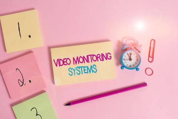 Writing note showing Video Monitoring Systems. Business photo showcasing Surveillance Transmit capture Image to Digital Link Blank notepads marker rubber band alarm clock clip colored background. — Stock Photo, Image