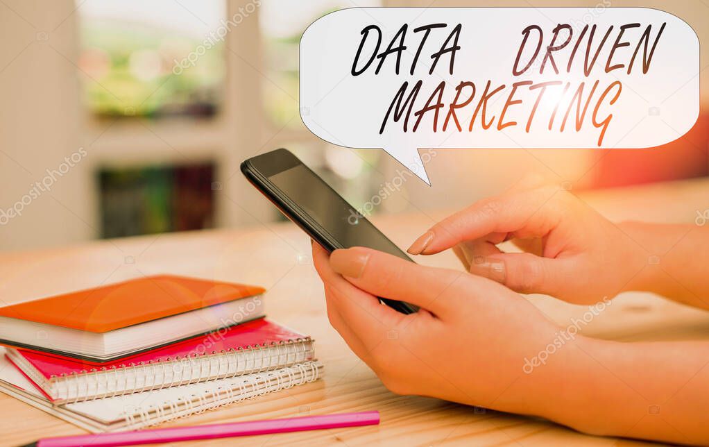 Conceptual hand writing showing Data Driven Marketing. Business photo text Strategy built on Insights Analysis from interactions woman using smartphone and technological devices inside the home.