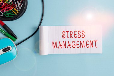 El yazısı Stres Yönetimi. Gerginliği ve etkilerini sınırlamak için bilgisayar faresi ile Pastel arkaplan üzerinde defter ve yazma araçları öğrenerek kavram oluşturma yöntemi.