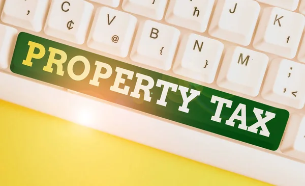 Writing note showing Property Tax. Business photo showcasing an ad valorem tax on the value of a property Millage rate White pc keyboard with note paper above the white background.