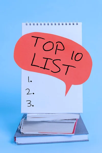 Γράφοντας σημείωμα που δείχνει Top 10 List. Επαγγελματική φωτογραφία που παρουσιάζει τα δέκα πιο σημαντικά ή επιτυχημένα στοιχεία σε μια συγκεκριμένη λίστα Spiral notebook ομιλία φούσκα στοιβάζονται παλιά βιβλία δροσερό παστέλ φόντο. — Φωτογραφία Αρχείου