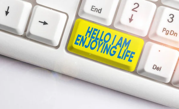 Scrittura di testo a mano Hello I Am Enjoying Life. Concetto che significa Felice stile di vita rilassato Godetevi cose semplici Tastiera bianca pc con carta nota vuota sopra lo spazio di copia chiave sfondo bianco . — Foto Stock