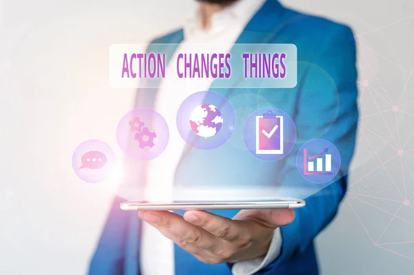 Conceptual hand writing showing Action Changes Things. Business photo text doing something will reflect other things Reaction Male human wear formal suit presenting using smart device.