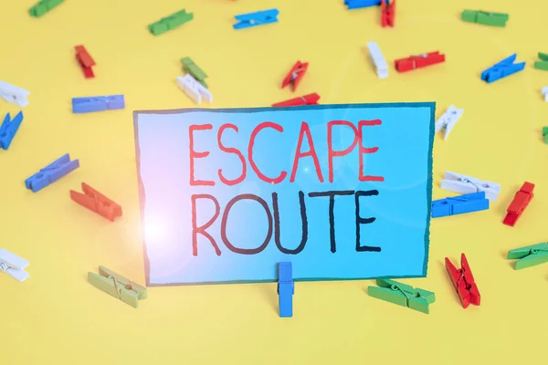 Text sign showing Escape Route. Conceptual photo a route by which a demonstrating may reach a place of safety Colored clothespin papers empty reminder yellow floor background office.