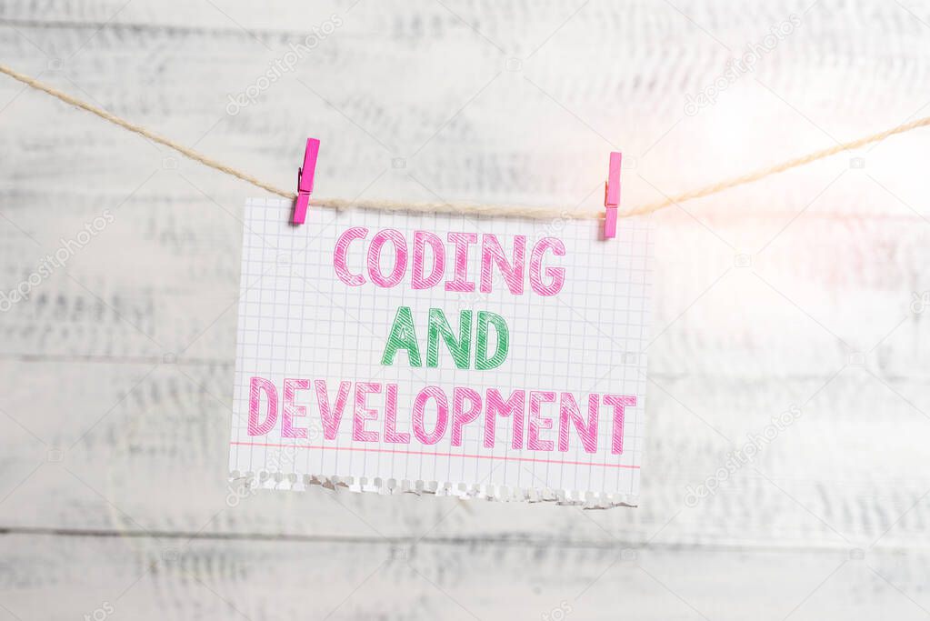Writing note showing Coding And Development. Business photo showcasing Programming Building simple assembly Programs Clothesline clothespin rectangle shaped paper reminder white wood desk.