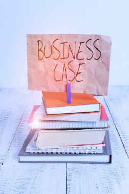 Business Case 'i gösteren bir not yazıyorum. İş fotoğrafı gösterme Teklifi Sözlü Sunum Yeni Görev yığını dizilmiş defterler not defteri renk hatırlatıcı beyaz ahşap.