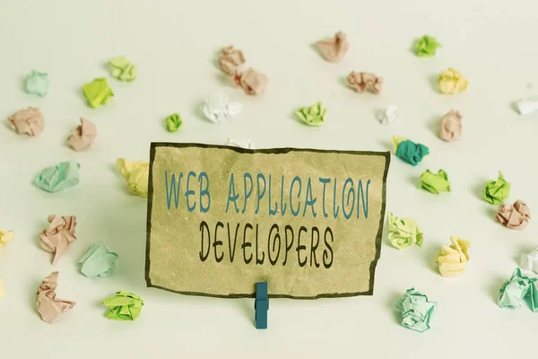 Text sign showing Web Application Developers. Conceptual photo Internet programming experts Technology software Colored crumpled papers empty reminder white floor background clothespin.