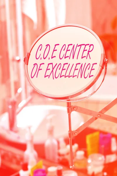 Text psaný rukou Coe Center Of Excellence. Koncept znamená být alfa vůdce ve své pozici Dosáhnout kulaté tvar zrcadlo a toaletní potřeby umístěné vedle dřezu v moderní koupelně. — Stock fotografie