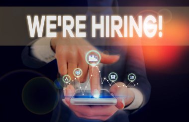 Yeniden işe aldığımızı gösteren kavramsal el yazısı. Uygulamaları incelemek ve aday bulmak için iş fotoğrafı metni süreci sunum akıllı aygıtı sunan iş elbisesi giyen bir kadın.