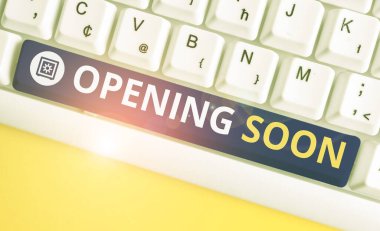 Handwriting text Opening Soon. Concept meaning an act or instance of making or becoming open to the public White pc keyboard with empty note paper above white background key copy space.