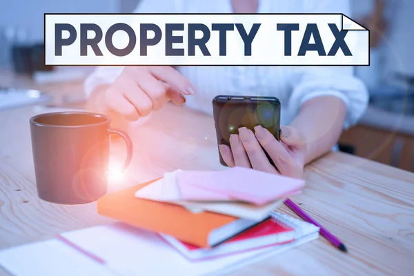 Handwriting text Property Tax. Concept meaning an ad valorem tax on the value of a property Millage rate woman using smartphone office supplies technological devices inside home.