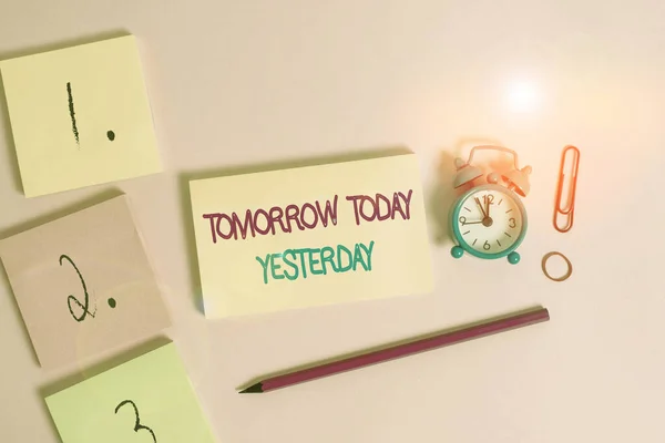 Writing note showing Tomorrow Today Yesterday. Business photo showcasing Adverbs of Time tells us when a thing happened Blank notepads marker rubber band alarm clock clip colored background.