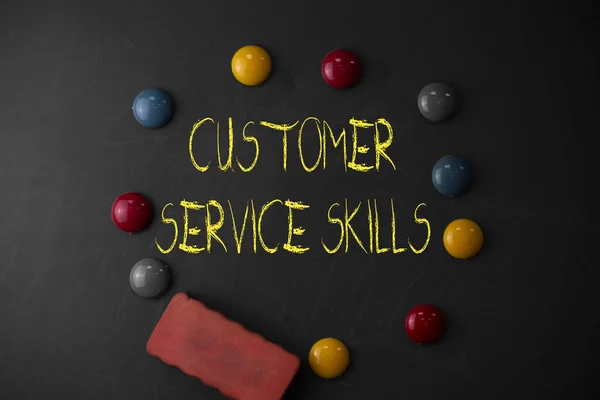 Word writing text Customer Service Skills. Business concept for Aptitude to master to improve dealings with client Round Flat shape stones with one eraser stick to old chalk black board.