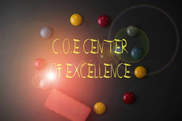 Word writing text Coe Center Of Excellence. Business concept for being alpha leader in your position Achieve Round Flat shape stones with one eraser stick to old chalk black board.