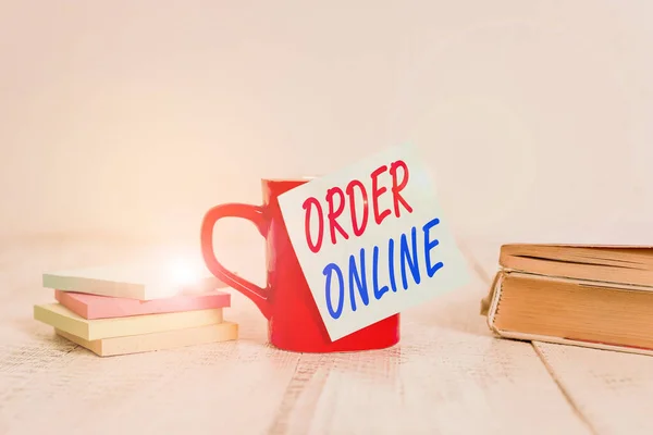 Signo de texto que muestra Order Online. Foto actividad conceptual de la compra de productos o servicios a través de Internet taza de café en blanco pegajoso nota apilados cuadernos de notas retro vieja mesa de madera . — Foto de Stock