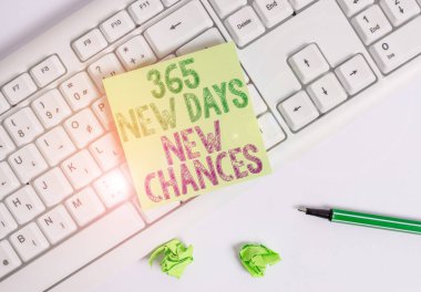 365 Yeni Gün Yeni Şansları gösteren bir not yazıyorum. İş fotoğrafı gösterimi Bir yıl daha Takvim Fırsatları Yeşil kağıt beyaz arkaplan ve pc klavye kalem ile.