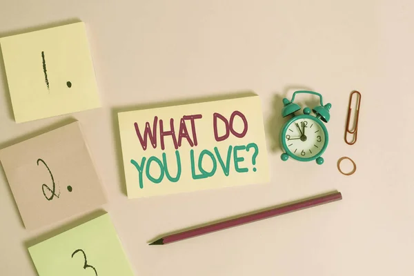 "What Do You Love Question" ı gösteren not yazıyorum. İş fotoğrafı sergiliyor. Eğlenceli şeyler. İlham verici şeyler için tutku. Not defterleri boş.. — Stok fotoğraf