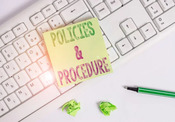 Writing note showing Policies And Procedure. Business photo showcasing list of rules defines customer and buyer rights Green note paper with pencil on white background and pc keyboard.