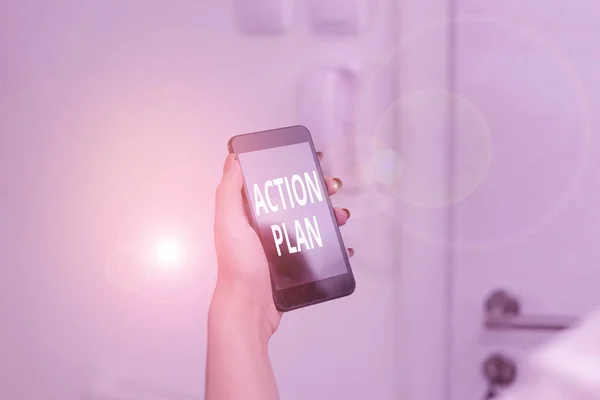 Word writing text Action Plan. Business concept for detailed plan outlining actions needed to reach goals or vision woman using smartphone office supplies technological devices inside home.
