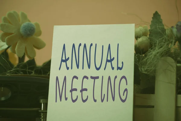 Handwriting text Annual Meeting. Concept meaning yearly meeting of the general membership of an organization Flowers and writing equipments plus plain sheet above textured backdrop. — 图库照片