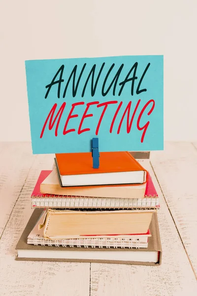 Handwriting text writing Annual Meeting. Concept meaning yearly meeting of the general membership of an organization pile stacked books notebook pin clothespin colored reminder white wooden. — 图库照片