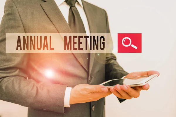 Handwriting text writing Annual Meeting. Concept meaning yearly meeting of the general membership of an organization Male human wear formal work suit hold smart hi tech smartphone use hands.